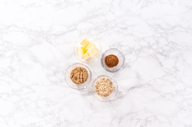 Flat lay Measured ingredients in a glass mixing bowl to prepare cinnamon crumb topping