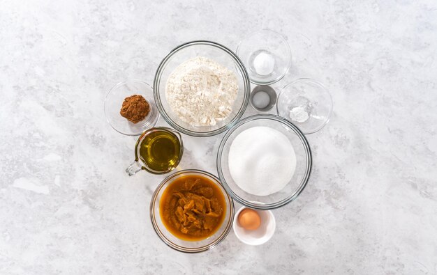 Flat lay. Measured ingredients in a glass mixing bowls to bake sweet pumpkin bread.