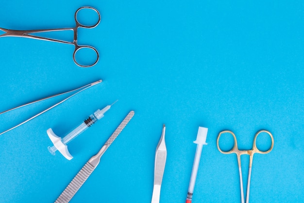 Flat lay of medical instruments on blue background.