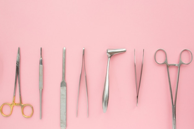 Flat lay of medical instruments on rose surface