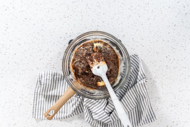 Flat lay Melting chocolate chips and other ingredients in a glass mixing bowl over boiling water to prepare plain fudge