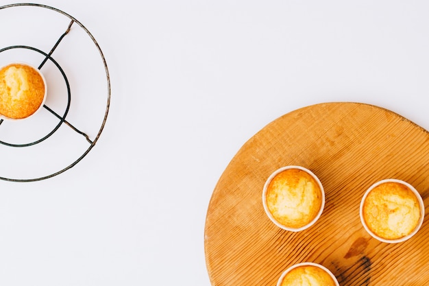 Flat lay minimalism homemade orange muffins on wooden board