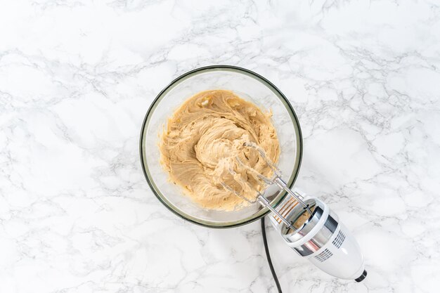 Flat lay Mixing ingredients in a large glass mixing bowl to bake banana oatmeal muffins