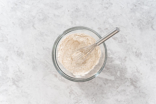 Flat lay Mixing ingredients in a large glass mixing bowl to bake eggnog scones