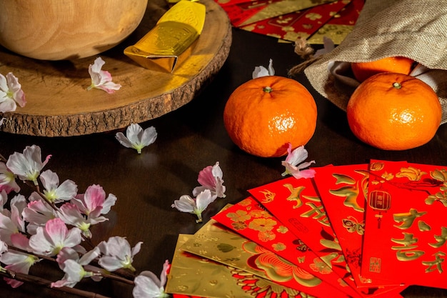 Flat lay mockup for holiday Chinese new year red packet and gold accessories blossom and Lunar festival background, means wealthy or rich and happiness.