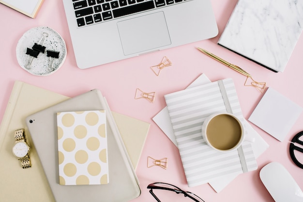 Flat lay modern feminine workspace with laptop and stationery