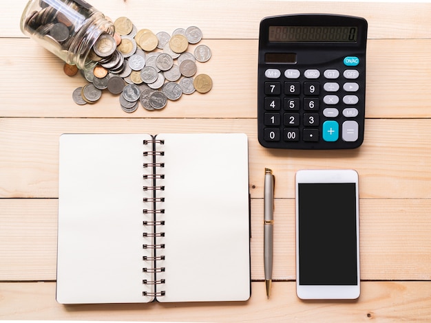 Flat lay of money, smartphone, calculator and notebook on a desk