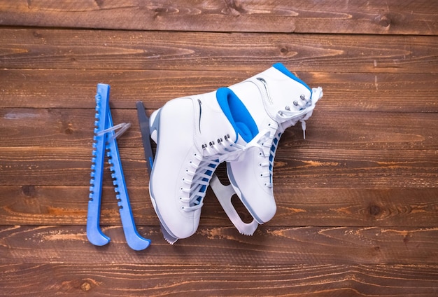 Flat lay. New white figure skates on a wooden boards.