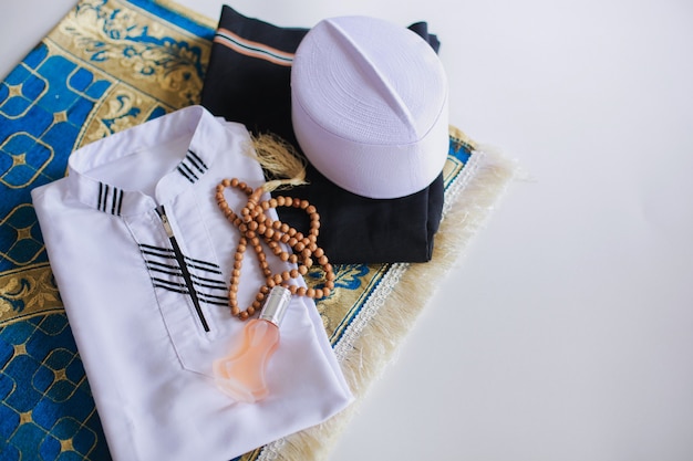 Плоская планировка мусульманского традиционного платья и четок на молитвенном коврике с копией пространства