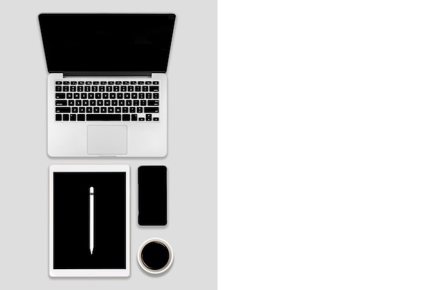 Фото Плоская планировка офисного стола с ноутбуком, цифровым планшетом, мобильным телефоном и аксессуарами.