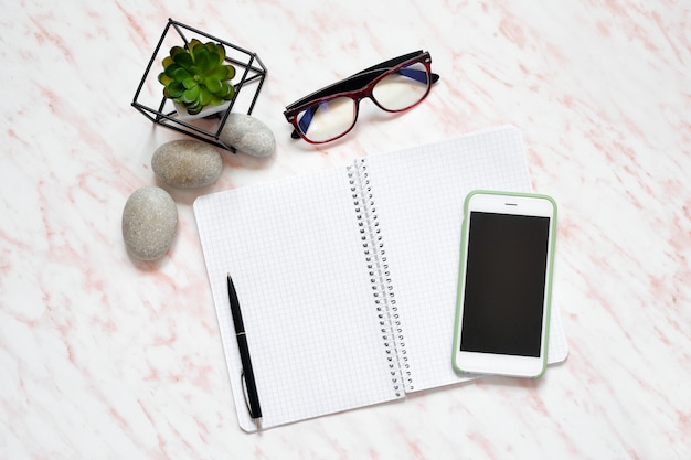 Photo flat lay office marble desk with phone, keyboard and notebook