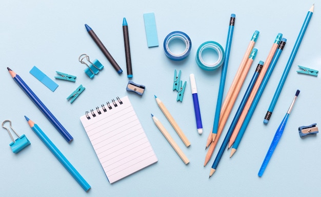 Flat lay of office school stationery on blue background