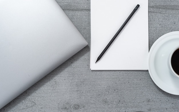 Disposizione piatta dello spazio ufficio con vista notebook portatile con matita e tazza di caffè.