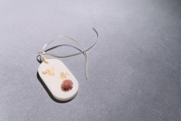 Flat lay of one Florentine Aromatic Sachet with Dried Flowers in Shape of an Oval on Gray Background