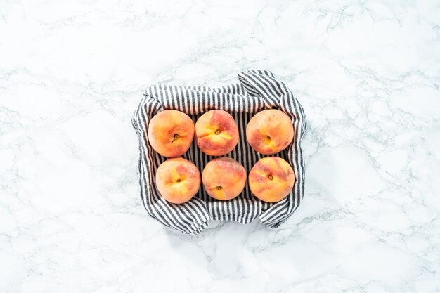 Flat lay. Organic whole peaches in a metal wired basket.