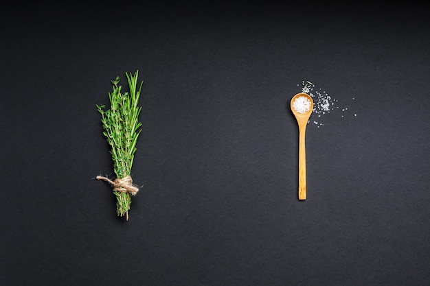 Photo flat lay overhead top view of greens herbs and spices on black background with copy space. menu frame design food pattern background with cooking ingredients