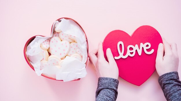 Photo flat lay. packing heart shaped sugar cookies decorated with royal icing into the gift box.