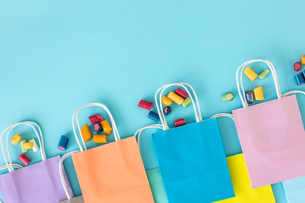 Flat lay paper bags and chewing gummies on a blue background