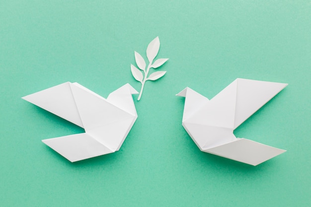 Flat lay of paper doves with leaves