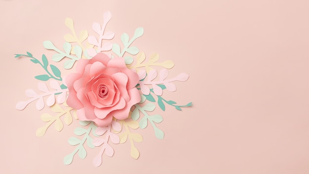 Flat lay of paper flowers on pastel pink background. Summer fashion and trendy frame