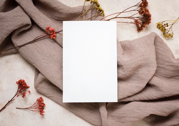 Flat lay of paper with autumn plant and fabric