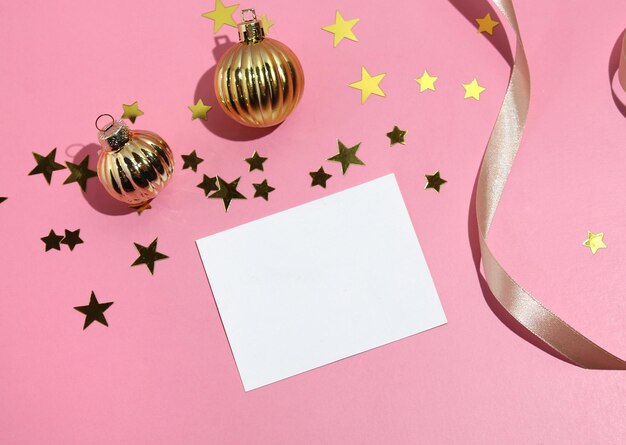 flat lay party decoration concept on pastel pink background with blank white card