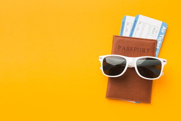 Photo flat lay of passport with sunglasses and plane tickets