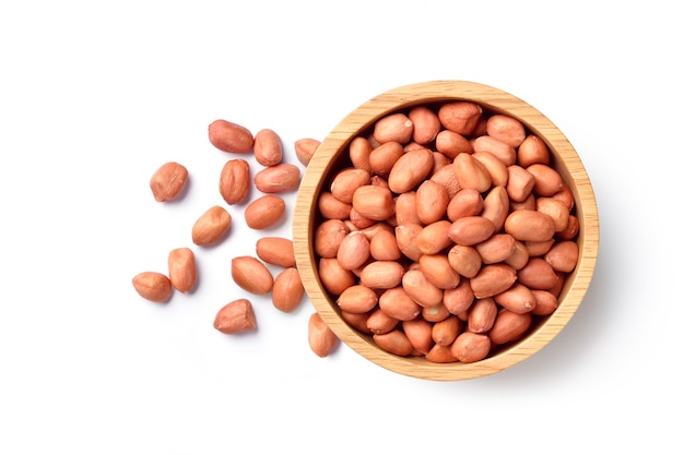 Flat lay of peanuts in wooden bowl isolated on white background.