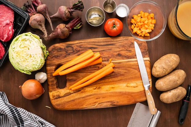 Flat lay. Peeling organic carrots to make beet soup.