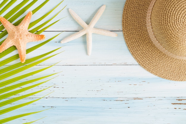 Flat lay photo coconut leaf and hat on wood background 