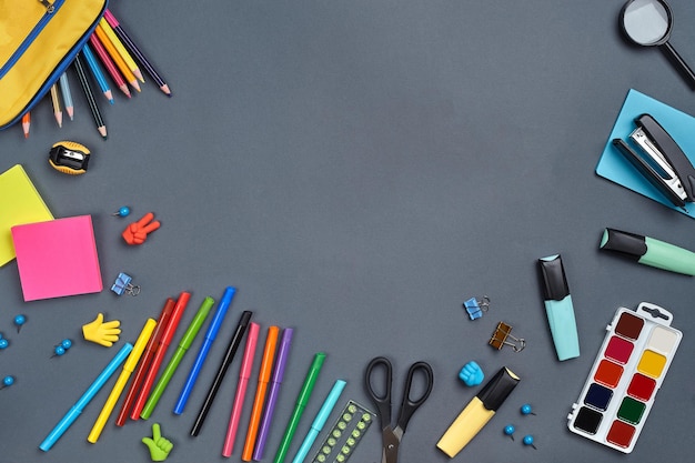 Flat lay photo of workspace desk with school accessories or office supplies on gray background