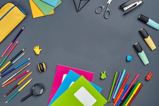 Flat lay photo of workspace desk with school accessories or office supplies on gray background