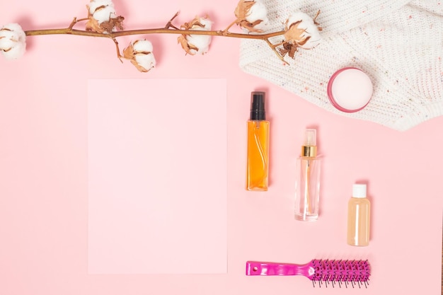 Flat lay pink composition with empty note cosmetics makeup tools