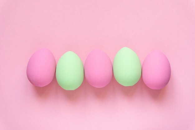 Flat lay of pink and green colored easter eggs