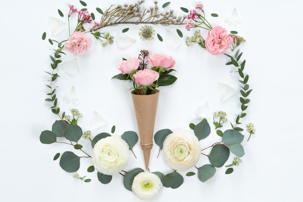 Photo flat lay of pink rose flowers in a eco paper cornet