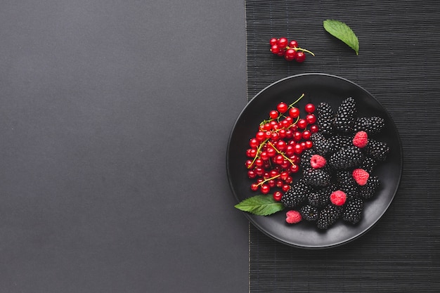 Photo flat-lay plate of fresh berries with copyspace