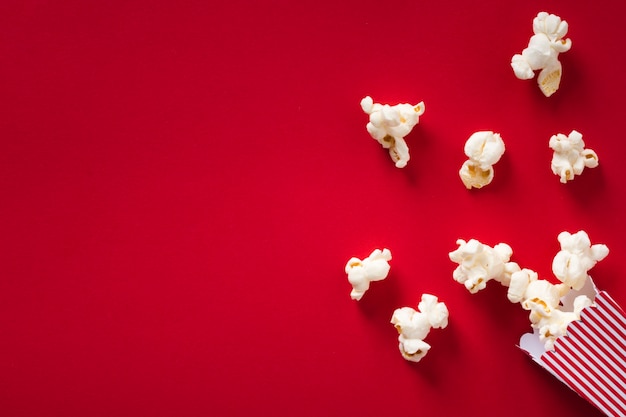 Foto popcorn piatto laici su sfondo rosso con spazio di copia