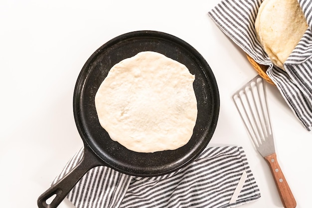 Flat lay. Preparing homemade flatbread on a cast-iron skillet.