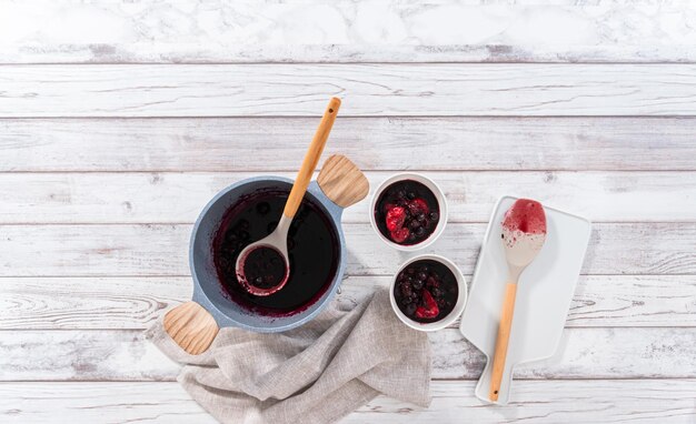 Flat lay Preparing mixed berry compote from frozen berries in a nonstick cooking pot