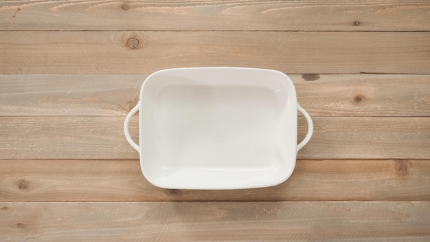 Flat lay. Preparing scalloped potatoes in a white ceramic baking dish.