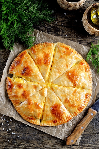 Flat lay of puff pastry cheese pie and dill