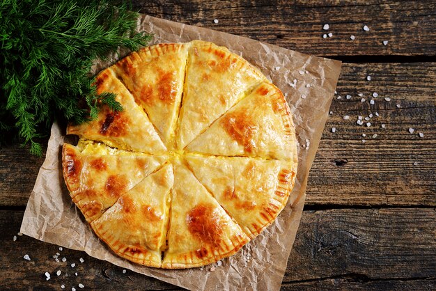 Flat lay of puff pastry cheese pie and dill