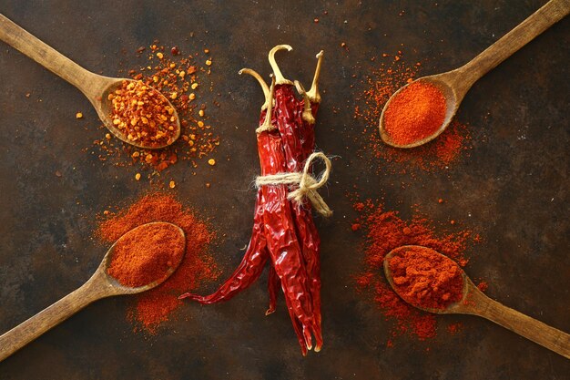 Flat lay red hot Chili peppers red pepper flakes and chilli powder on black background