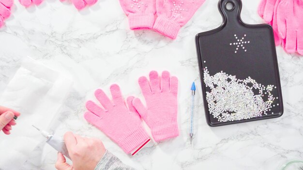 Flat lay. Rhinestone pink kids gloves with snowflake shapes.