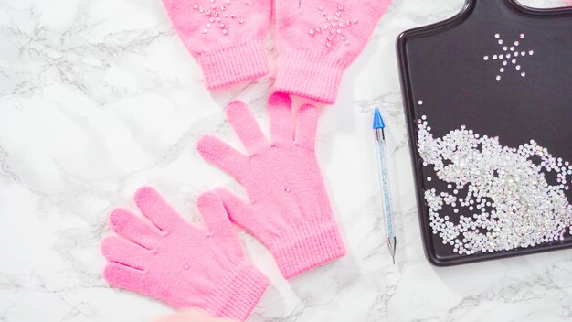 Disposizione piatta. guanti rosa per bambini con strass a forma di fiocco di neve.