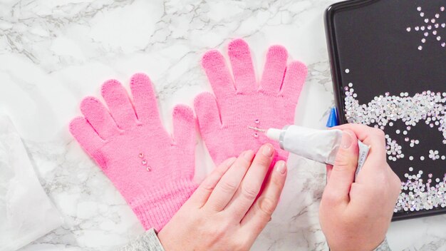 Flat lay. Rhinestone pink kids gloves with snowflake shapes.