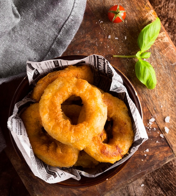 Photo flat lay of ring fries in bowl with tomato