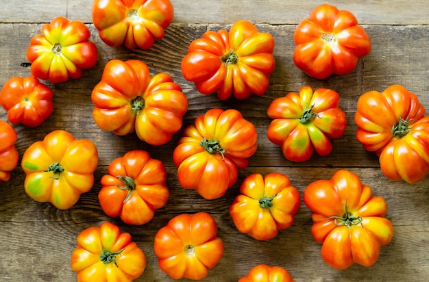 Flat lay of ripe red tomatoes on old wooden background