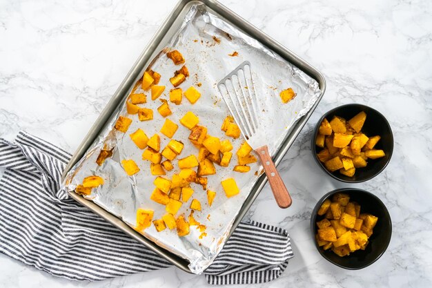 Flat lay. Roasting butternut squash with salt and pepper in olive oil.