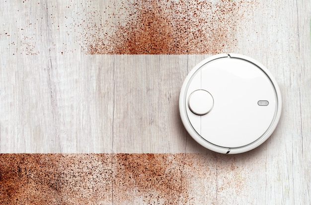 Flat lay of robotic vacuum cleaner cleaning a dirty floor